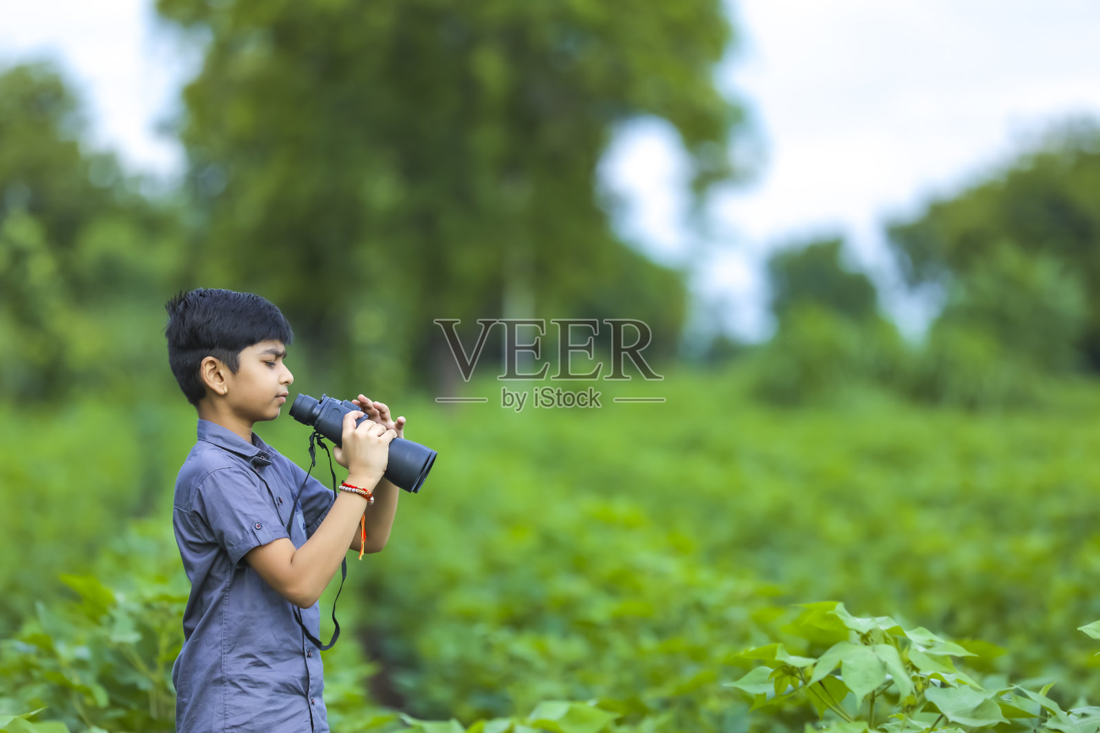 印度小男孩喜欢用望远镜观察大自然照片摄影图片