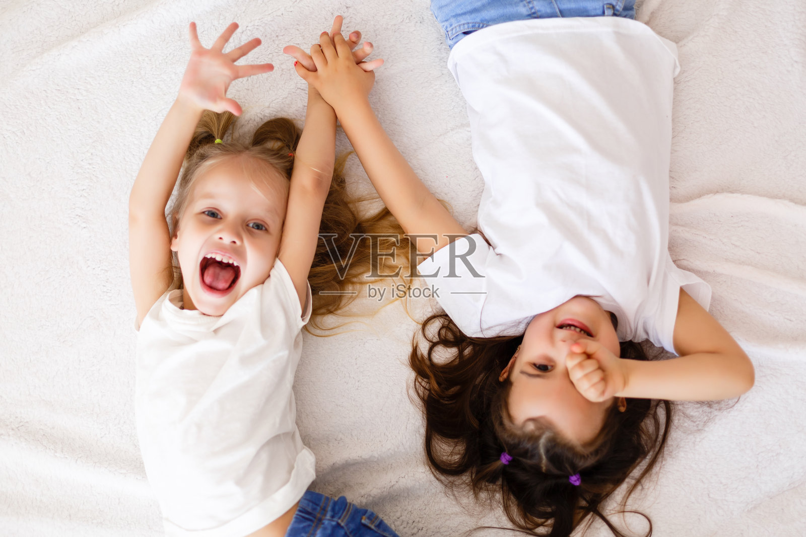 快乐的小女孩躺在后面俯视图姐妹照片摄影图片