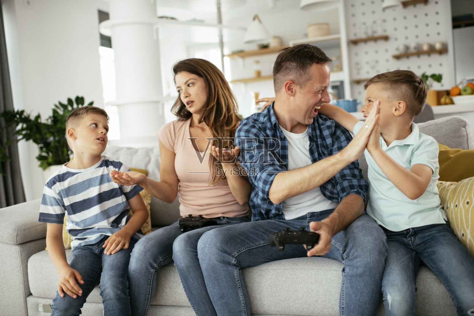 一对恩爱的夫妇在家里和孩子们玩电子游戏照片摄影图片