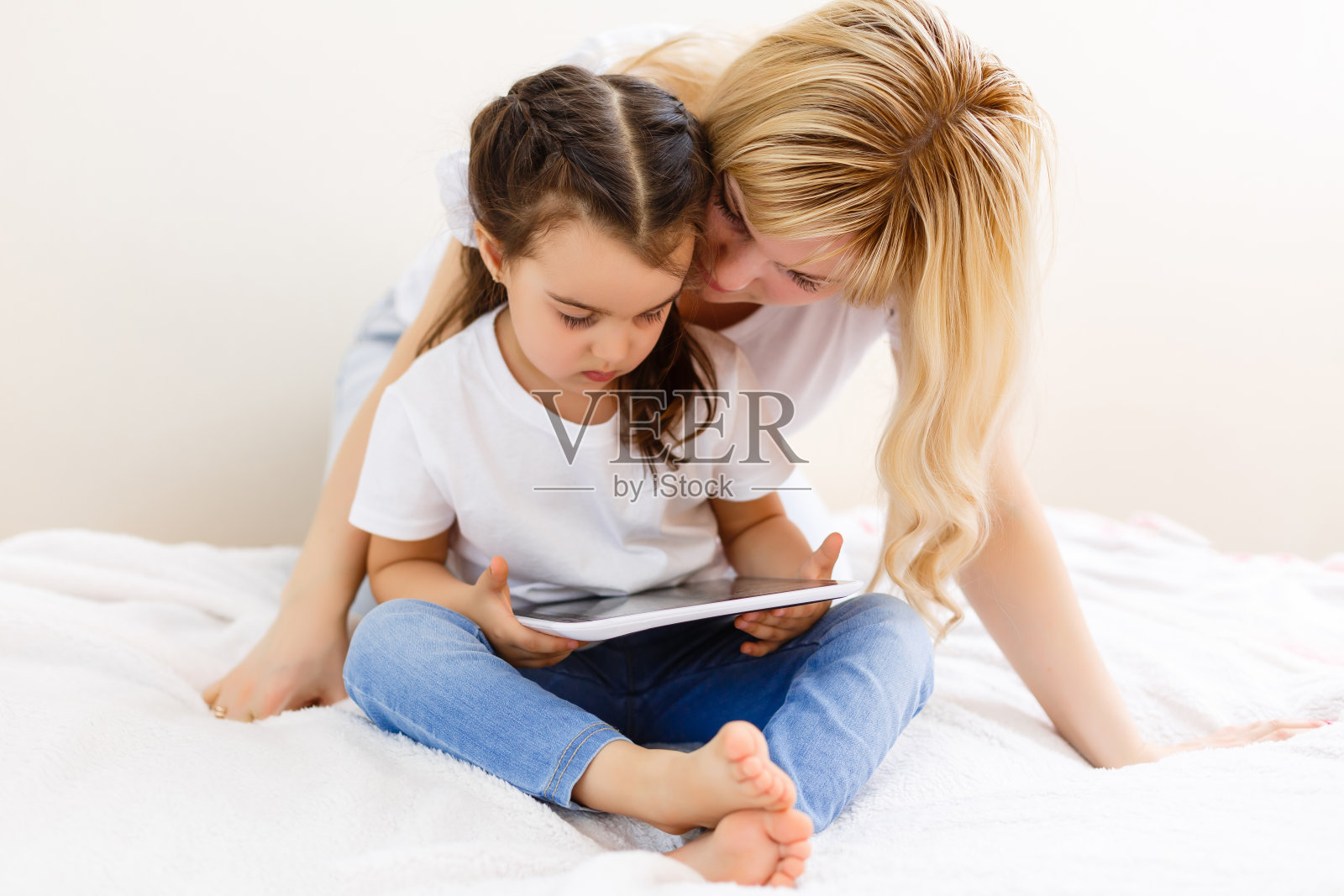 母亲和婴儿希望在家里的沙发上玩和阅读平板电脑照片摄影图片