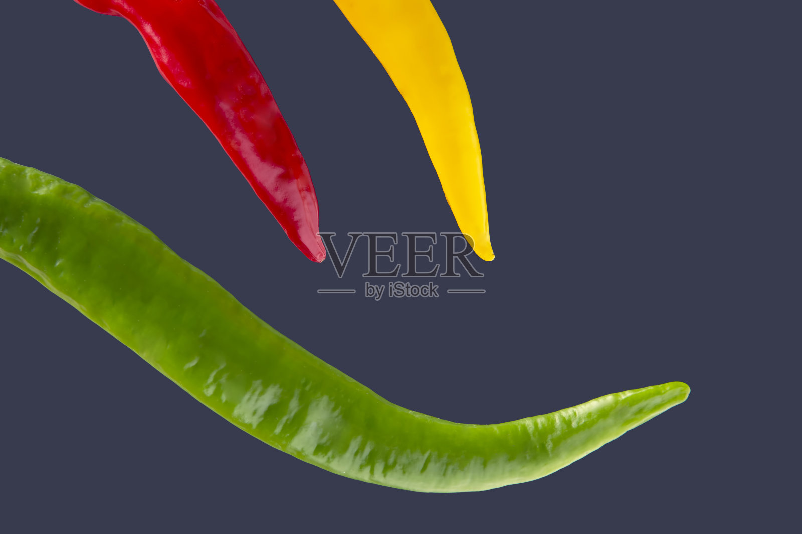 深蓝色背景上的彩色辣椒。胡椒。蔬菜维生素的食物。照片摄影图片