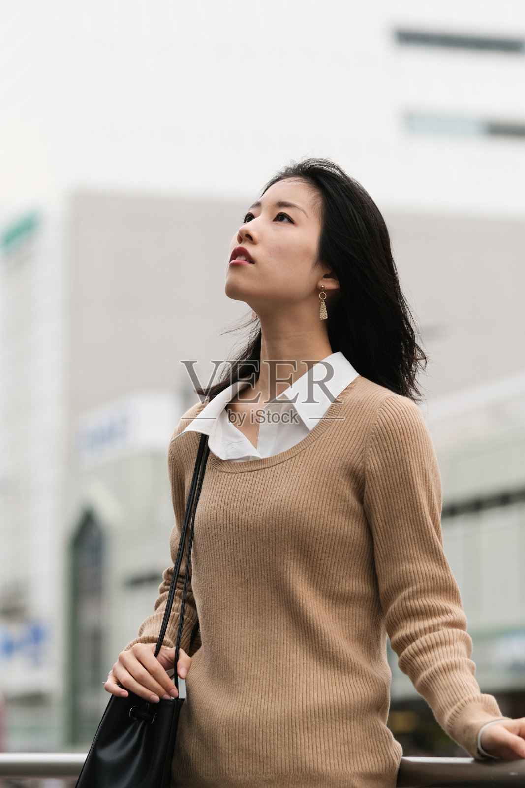 年轻女子在街上四处张望的肖像照片摄影图片