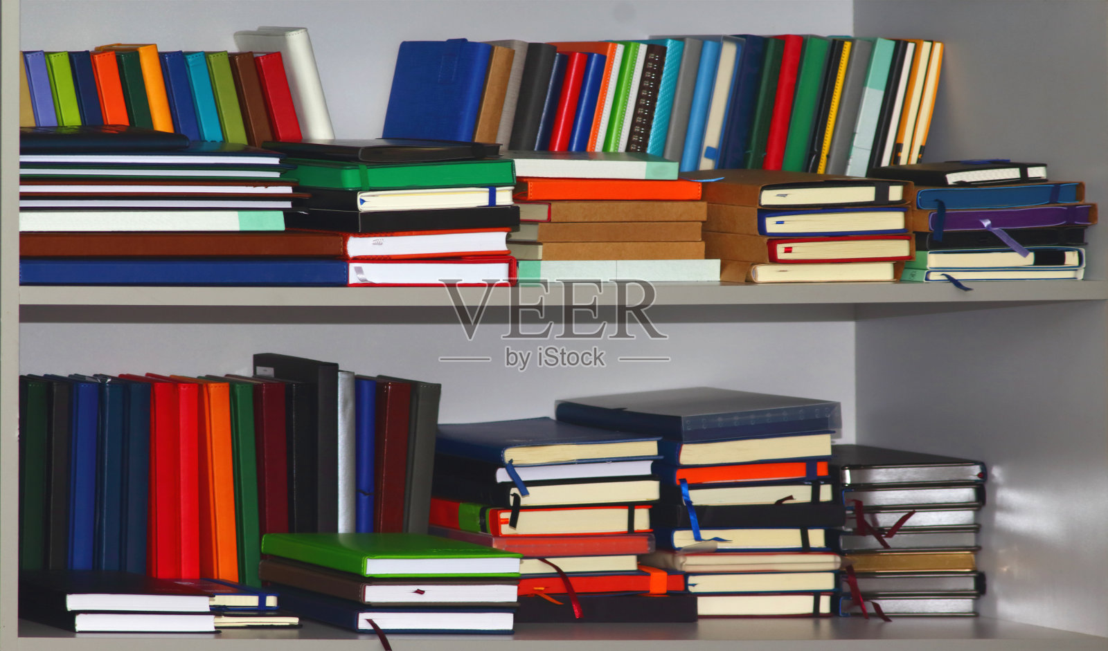 灰色书柜里堆放着各种皮面的日记或书籍照片摄影图片