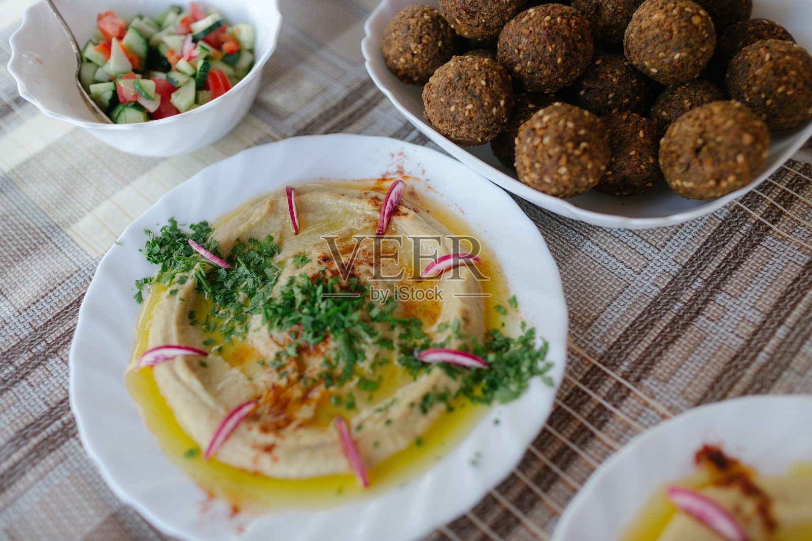 餐桌上摆满了中东菜肴，如鹰嘴豆泥、鹰嘴豆丸子和沙拉照片摄影图片