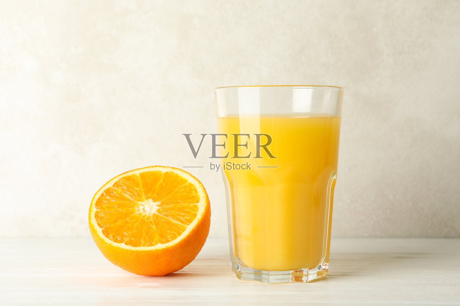 白色木桌上放着一杯新鲜的橙汁照片摄影图片