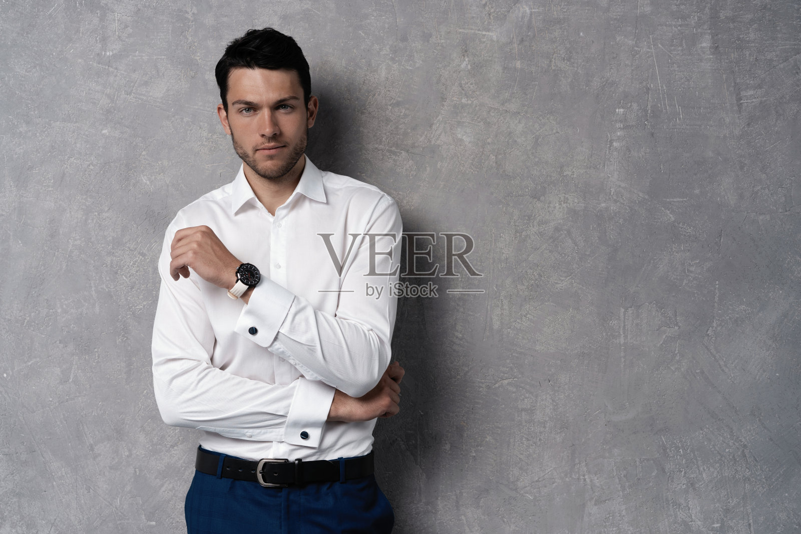 英俊的男子穿着蓝色西装孤立在灰色背景。照片摄影图片