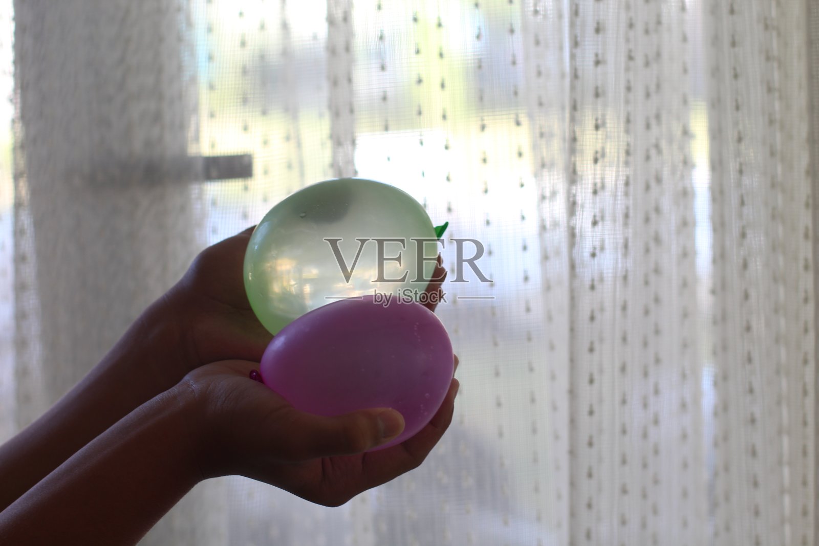 一个手里拿着水球的女孩照片摄影图片