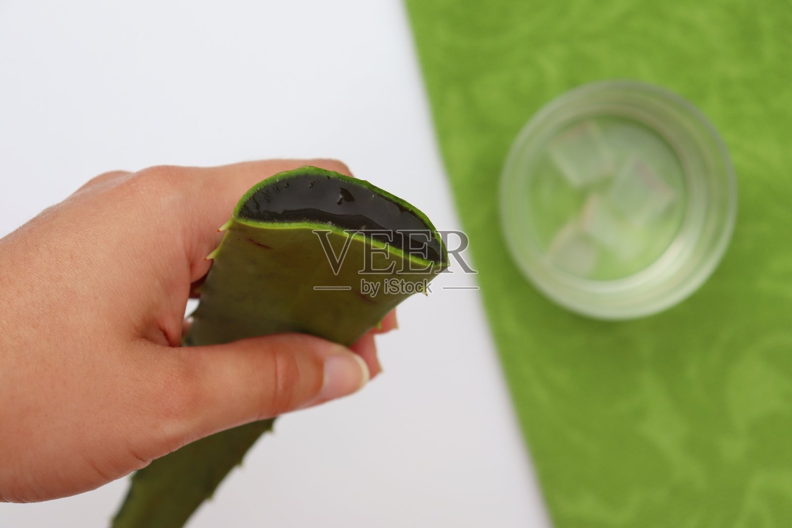 女人拿着芦荟叶和芦荟汁在背景照片摄影图片