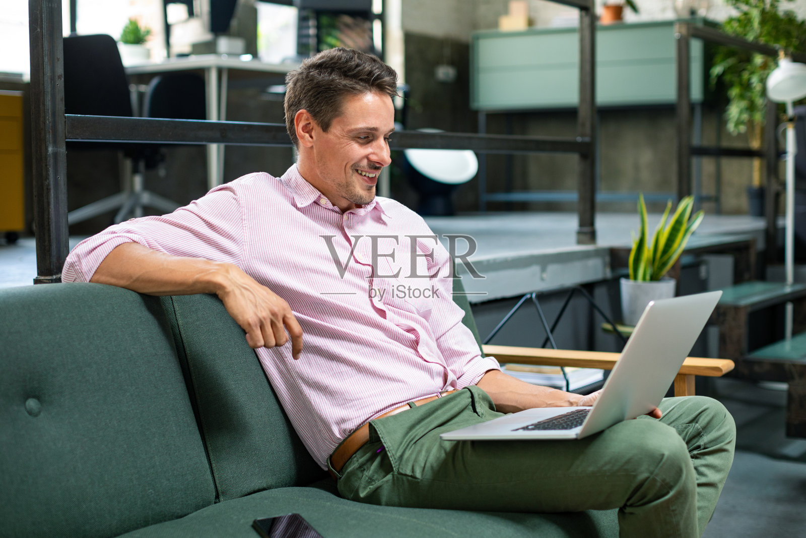 坐在沙发上的英俊商人照片摄影图片