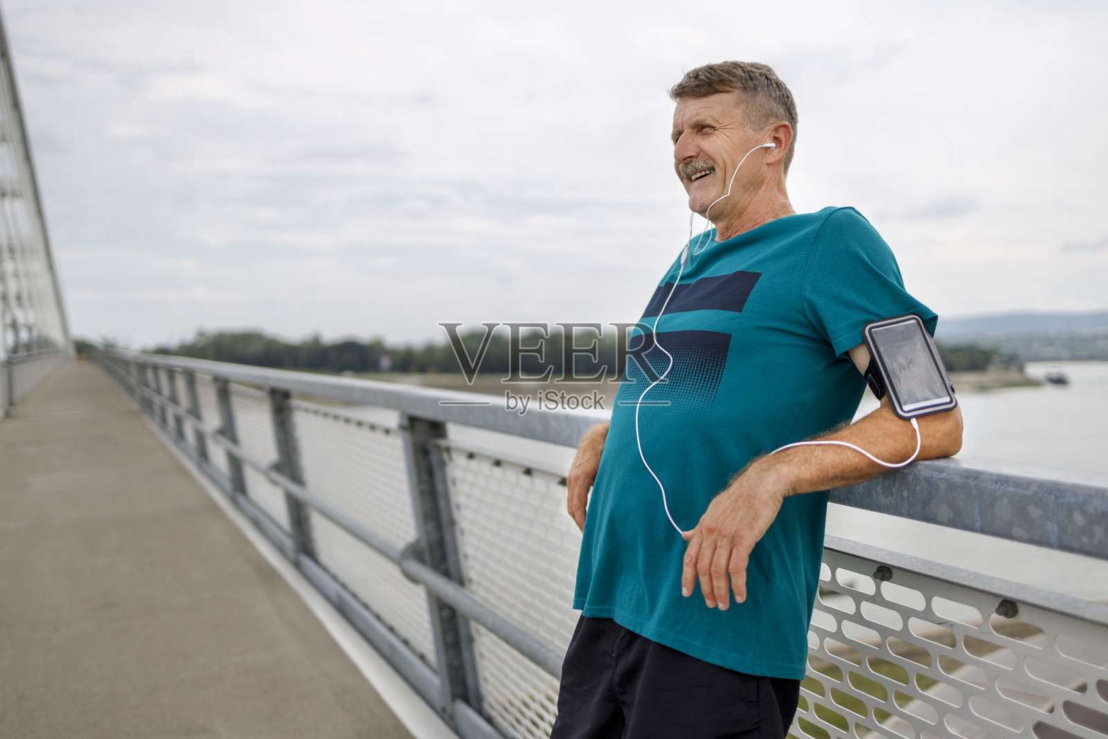 资深慢跑者在户外锻炼后放松，听音乐照片摄影图片