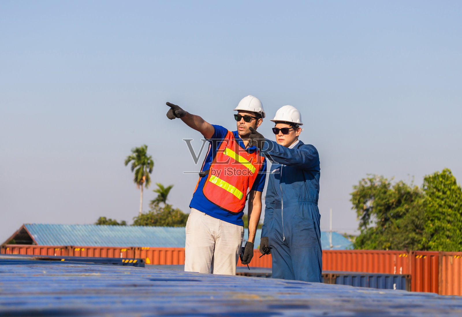 工厂工人戴安全帽和安全背心和工头检查控制集装箱从货物箱，团队合作的概念照片摄影图片