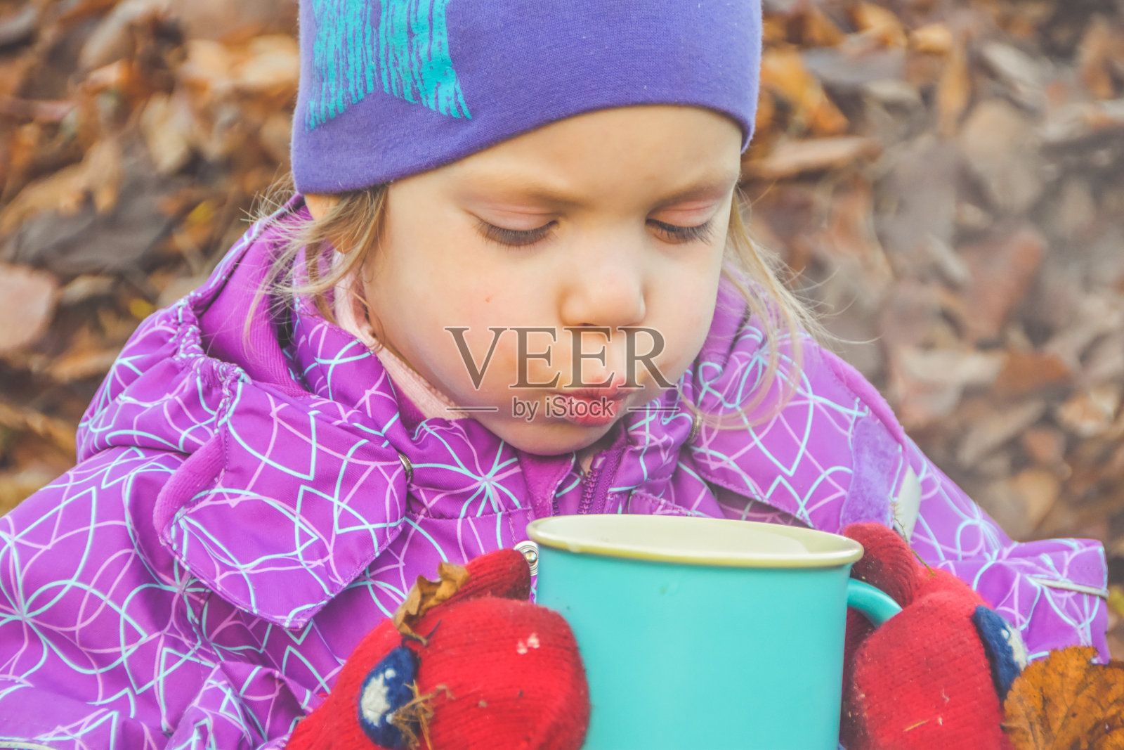 在一个阳光明媚的秋日，孩子躺在树叶上，很快乐照片摄影图片