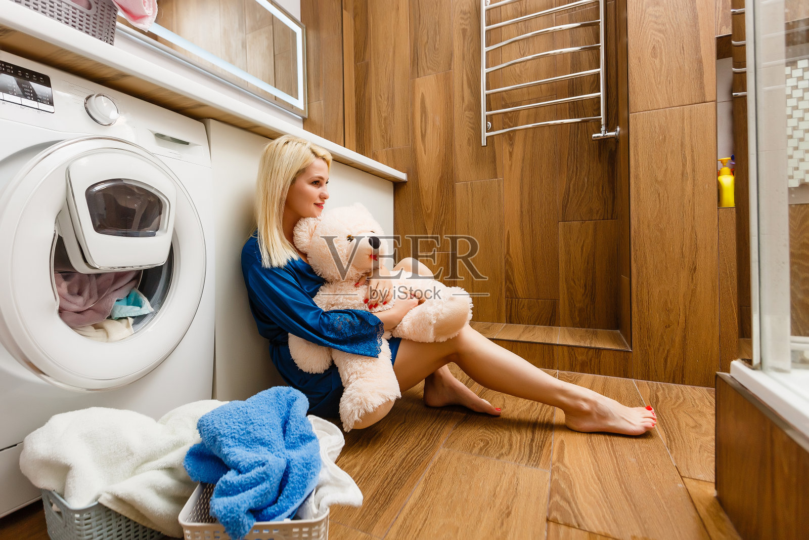 微笑的年轻女子与毛巾看别处，而坐在浴室照片摄影图片