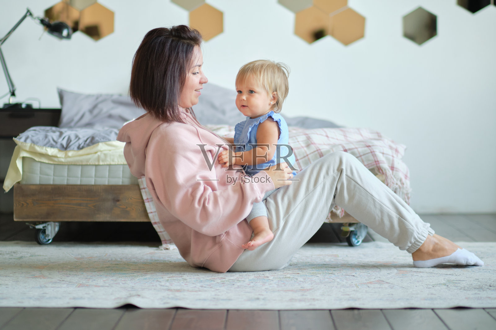 妈妈和孩子坐在客厅的演播室里一起玩。快乐的母亲。教育的爱照片摄影图片