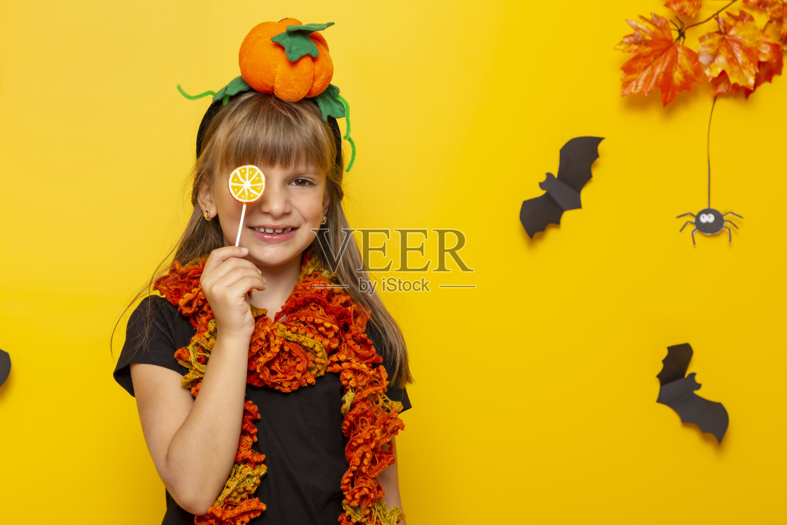 小女孩拿着棒棒糖在万圣节不给糖就捣蛋照片摄影图片