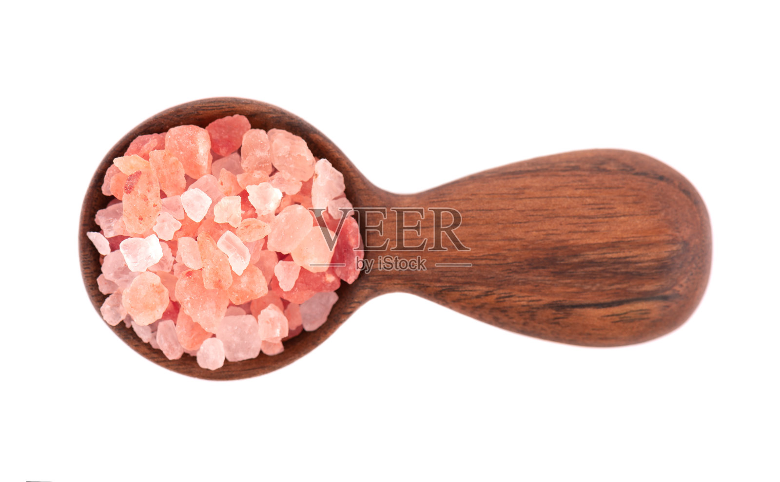 木勺里的喜马拉雅粉盐，孤立在白色背景上。喜马拉雅粉盐晶体。照片摄影图片