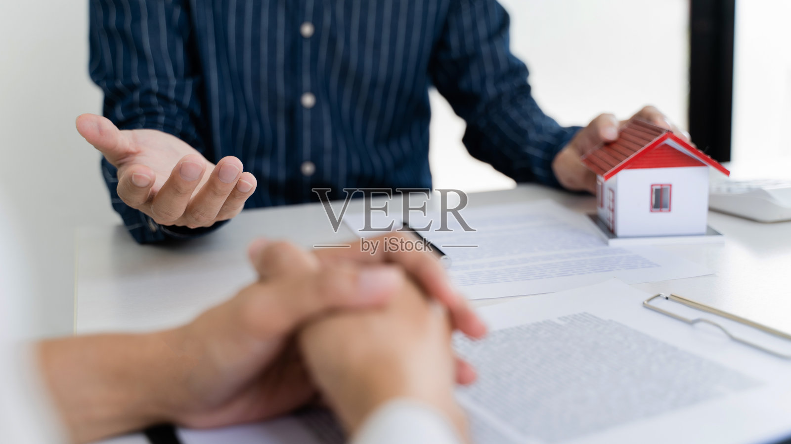 房地产经纪人与客户签订买房合同。照片摄影图片