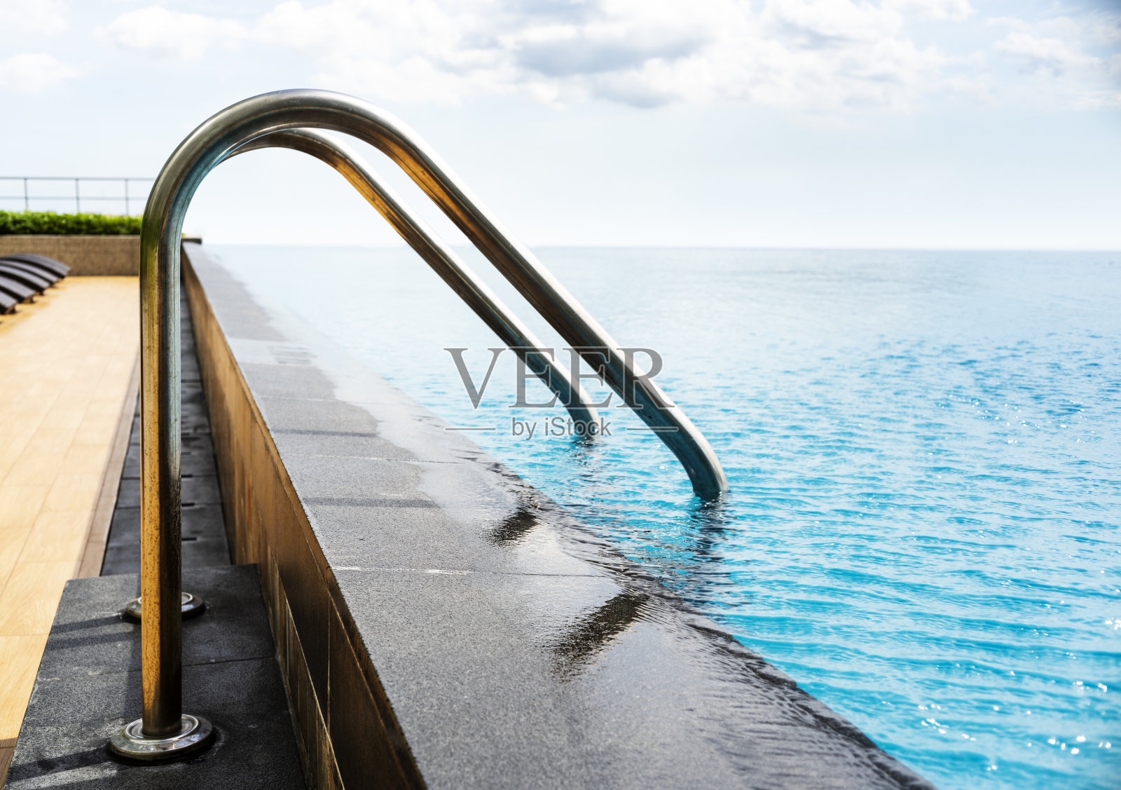 带有楼梯和木制甲板的游泳池照片摄影图片