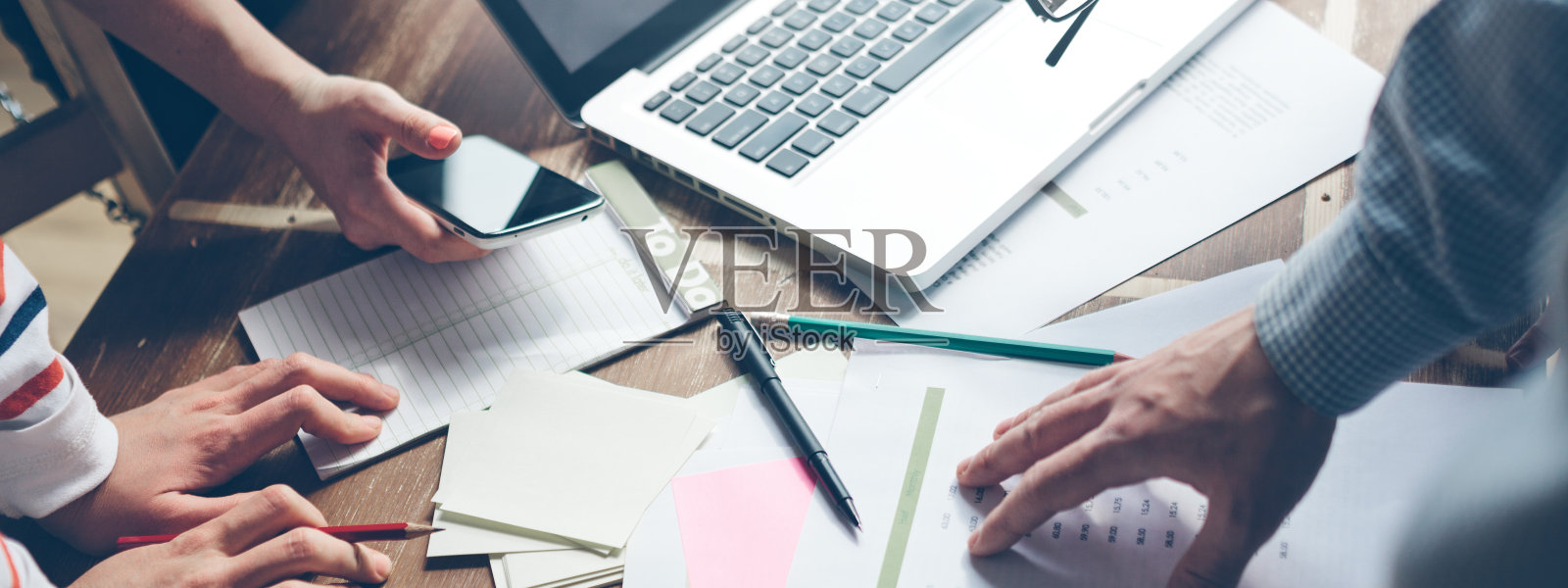 团队头脑风暴新项目。笔记本电脑和办公室文件。照片摄影图片