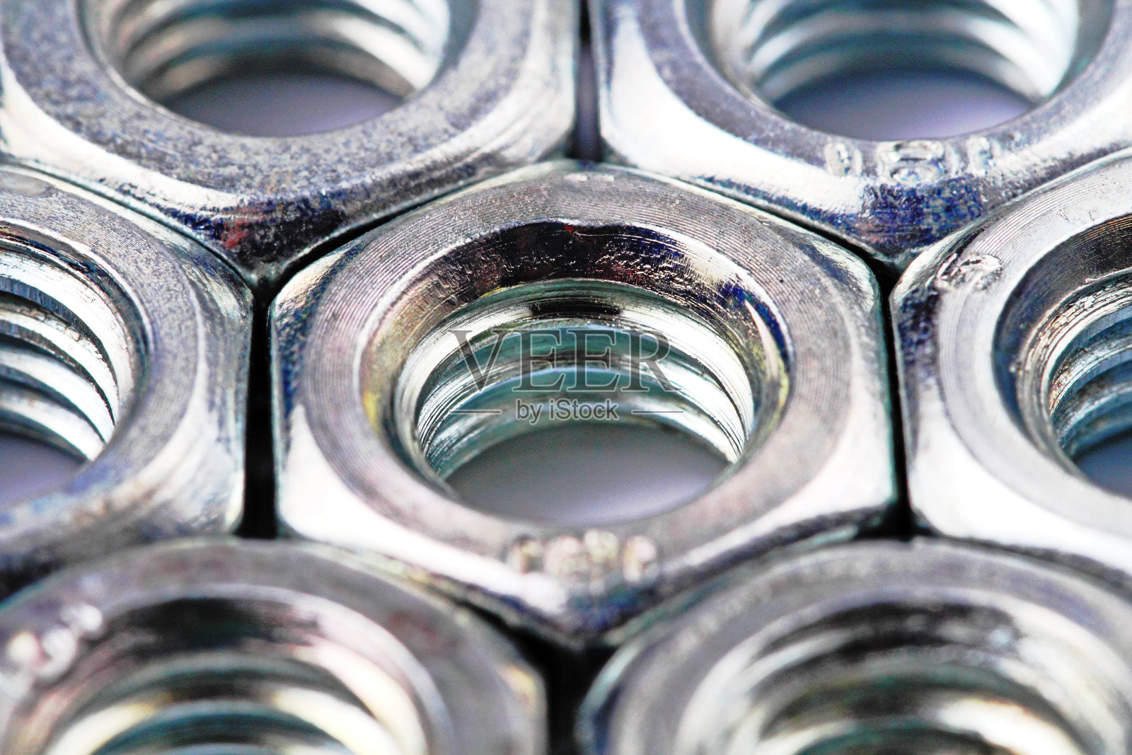 涂层钢螺母特写在一个白色的背景。照片摄影图片