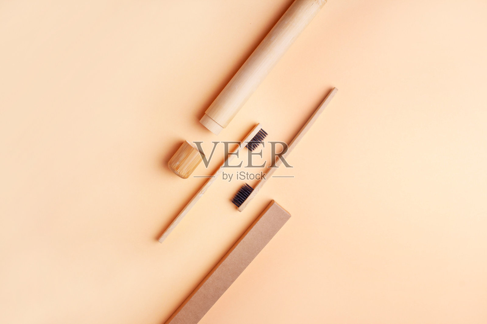 两把木制牙刷，以桃色为背景。平躺风格照片摄影图片