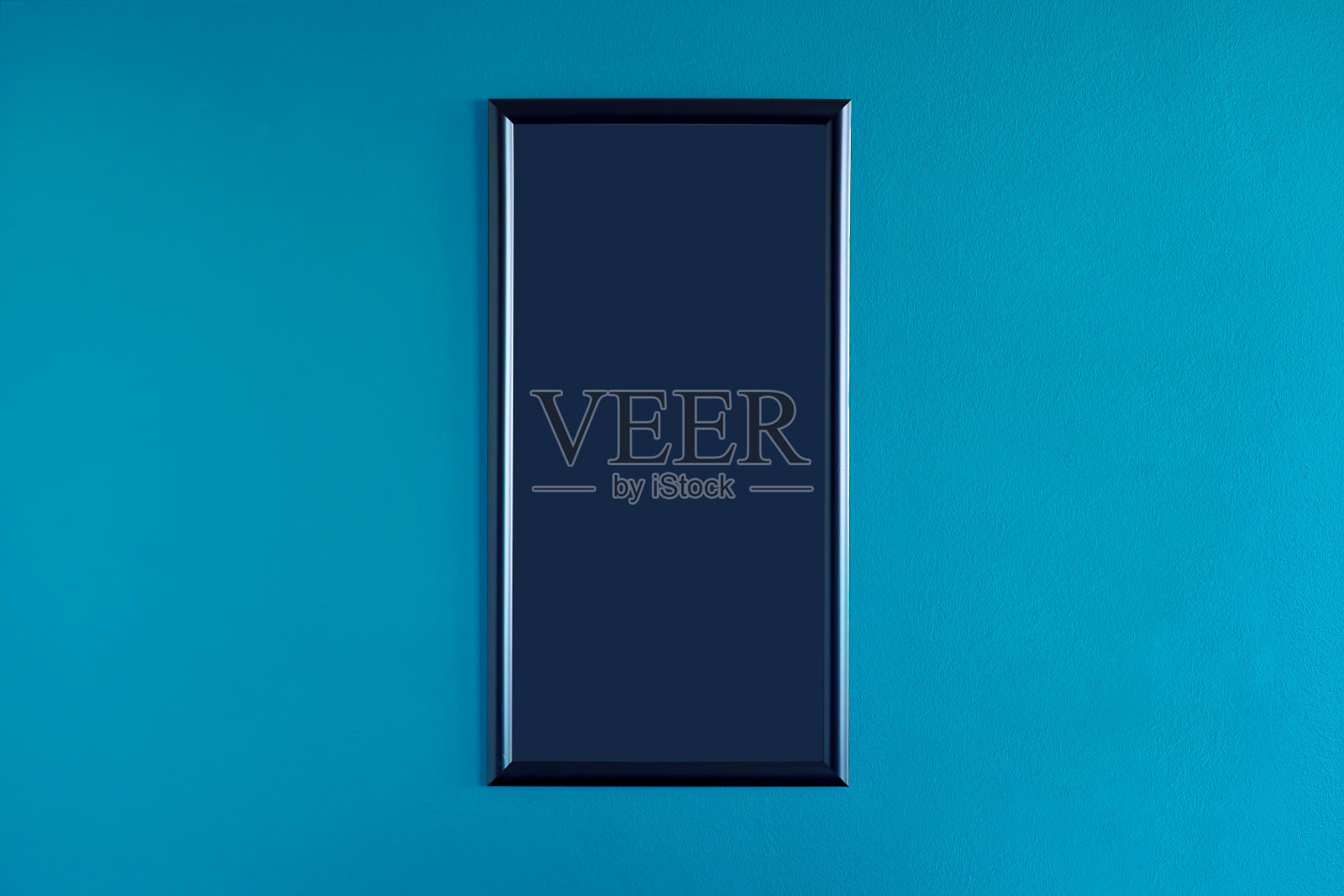 黑色，空白的框架挂在内部的蓝色墙壁上。空框架模拟。照片摄影图片