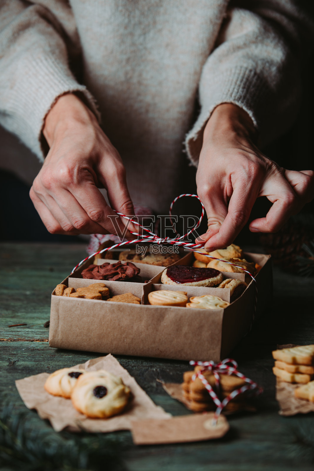 女人用手装饰圣诞小纸盒姜饼照片摄影图片