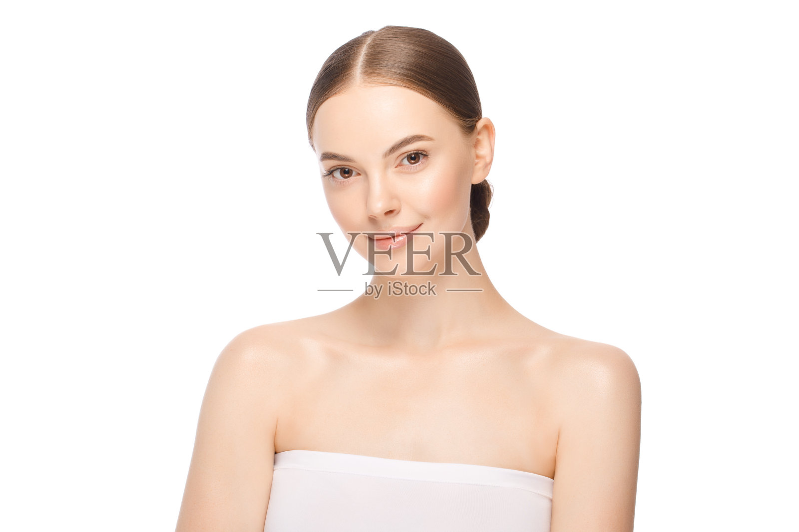 美女脸与棕色眼睛看着相机，孤立在白色的背景。美丽的模特与完美的干净新鲜的皮肤。护肤治疗或化妆品广告照片摄影图片