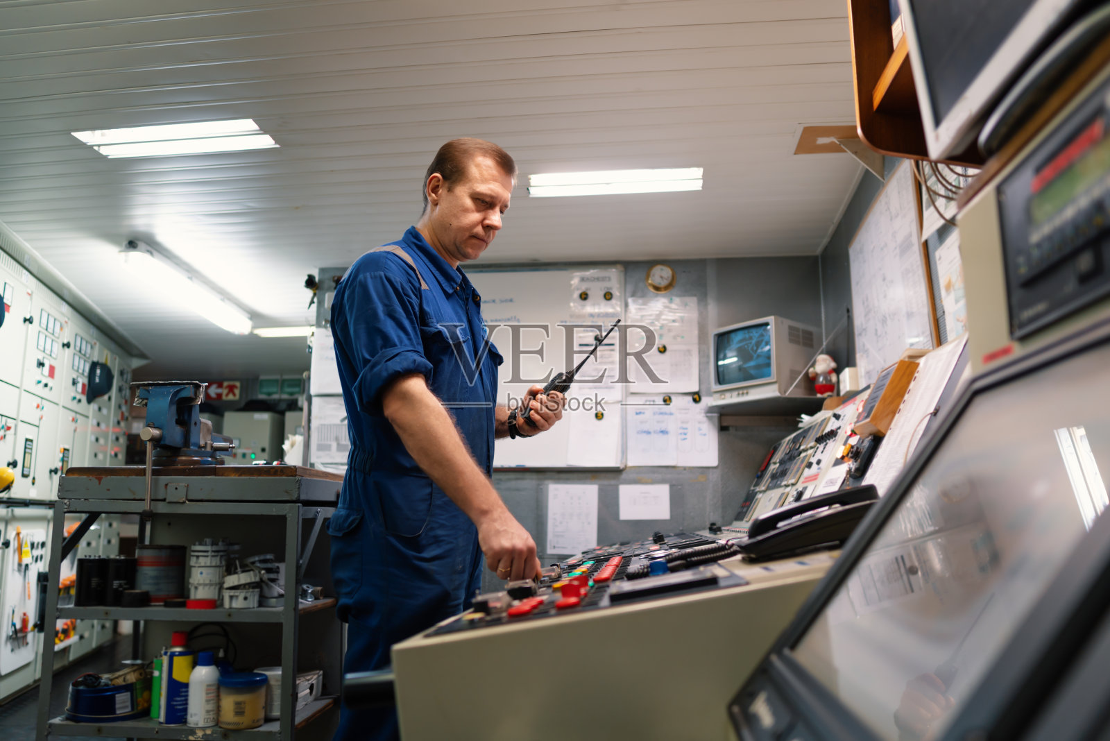 在轮机控制室ECR从事无线电通信工作的轮机工程师照片摄影图片