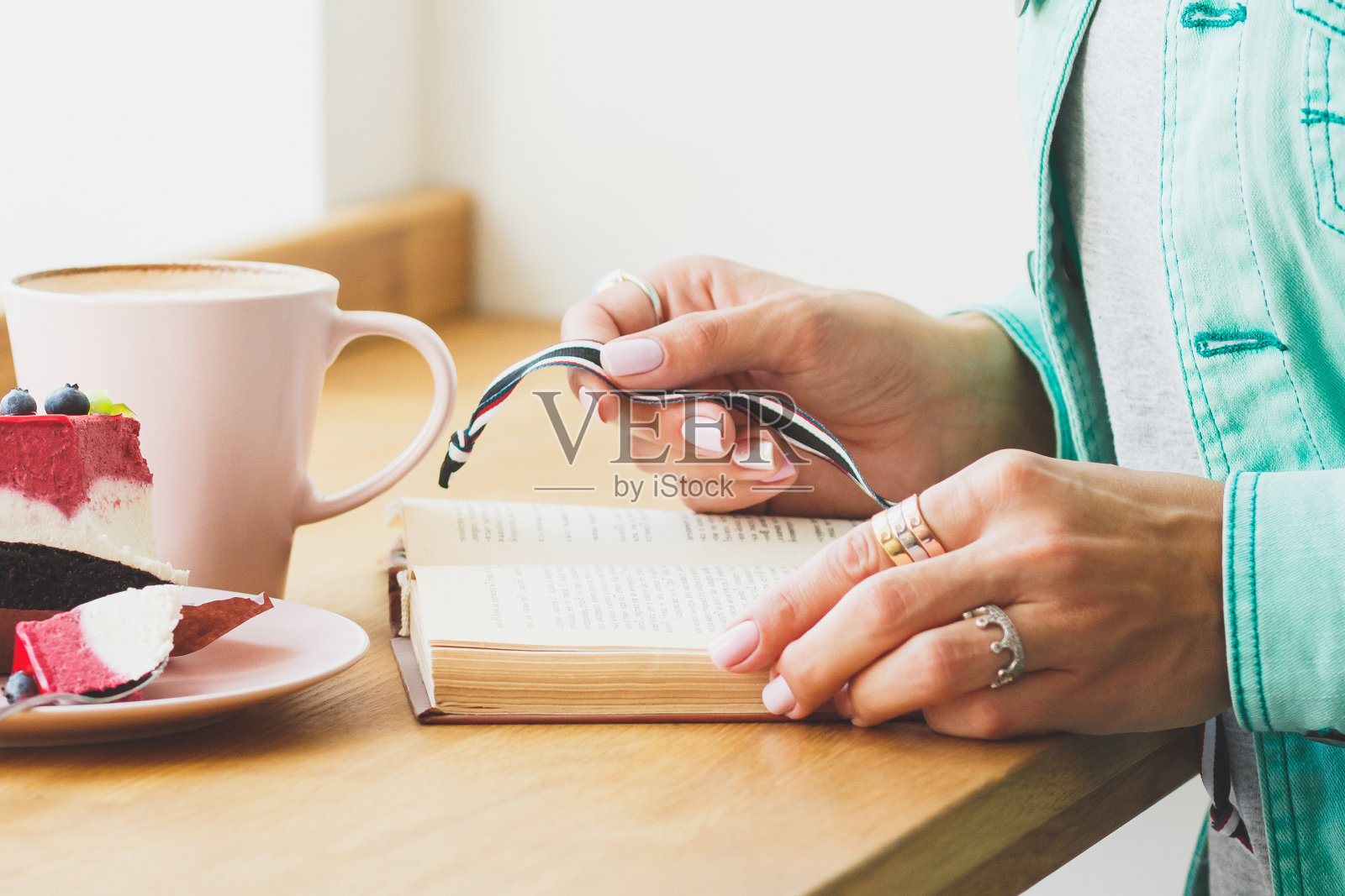 盘子里有一杯卡布奇诺和一块甜点的女人照片摄影图片