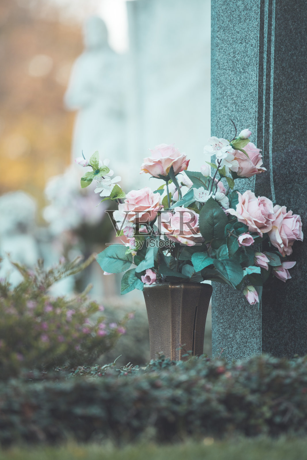 悲伤的概念。铁碗圣水，墓地，鲜花照片摄影图片