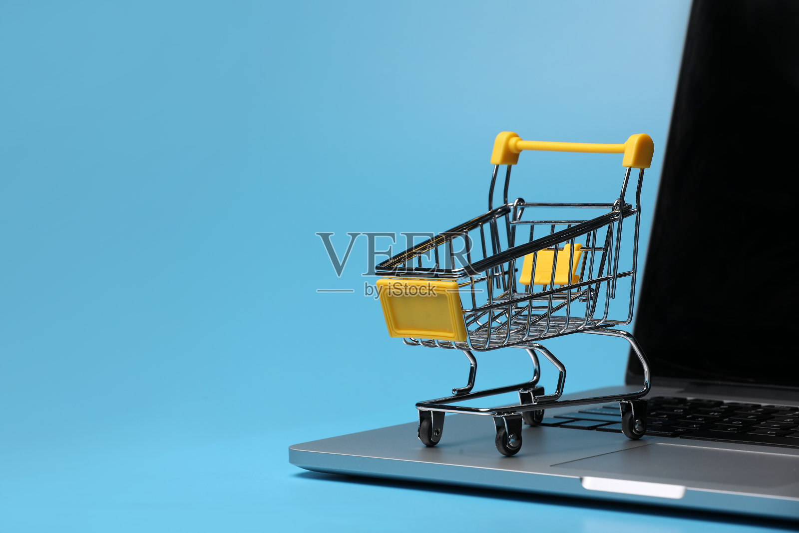 笔记本电脑上的一个空购物车。网上购物的象征性图片照片摄影图片