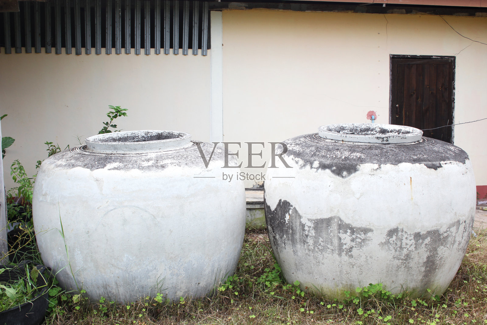 泰国乡村房屋前的大陶罐。照片摄影图片