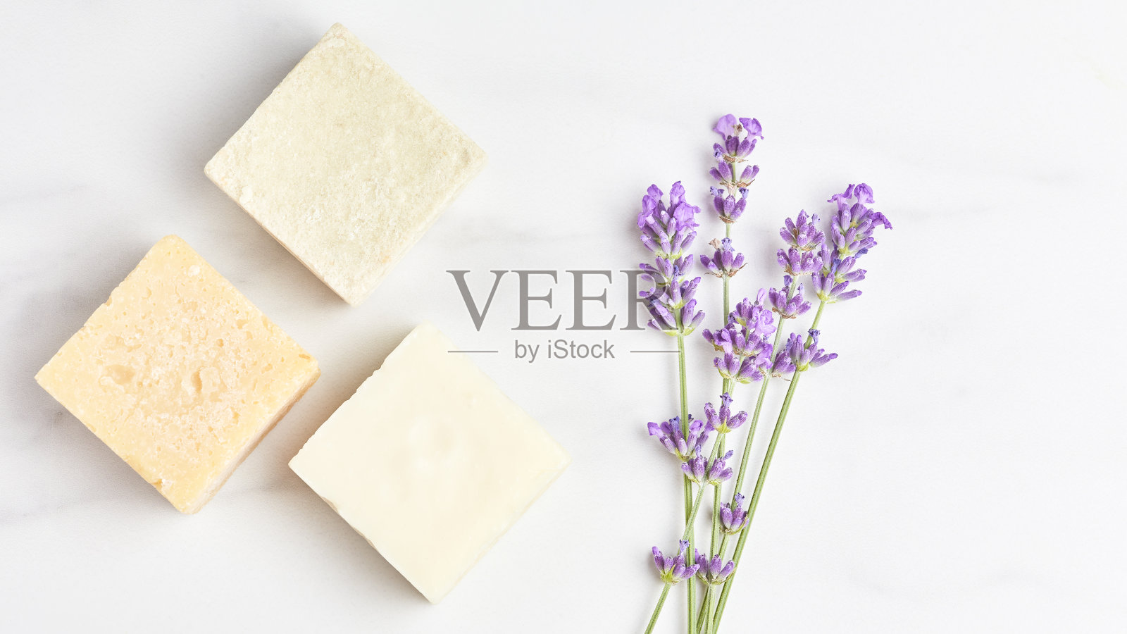 化妆品概念全景横幅。大理石背景上的薰衣草花和天然肥皂条。平躺，俯视图照片摄影图片