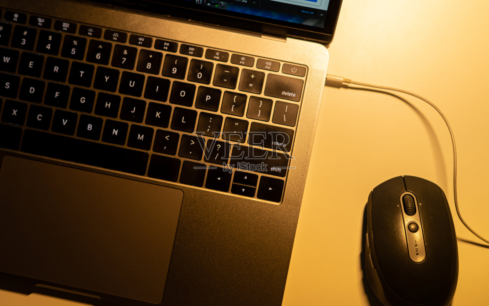 晚上在笔记本电脑键盘上打字的手的特写照片摄影图片