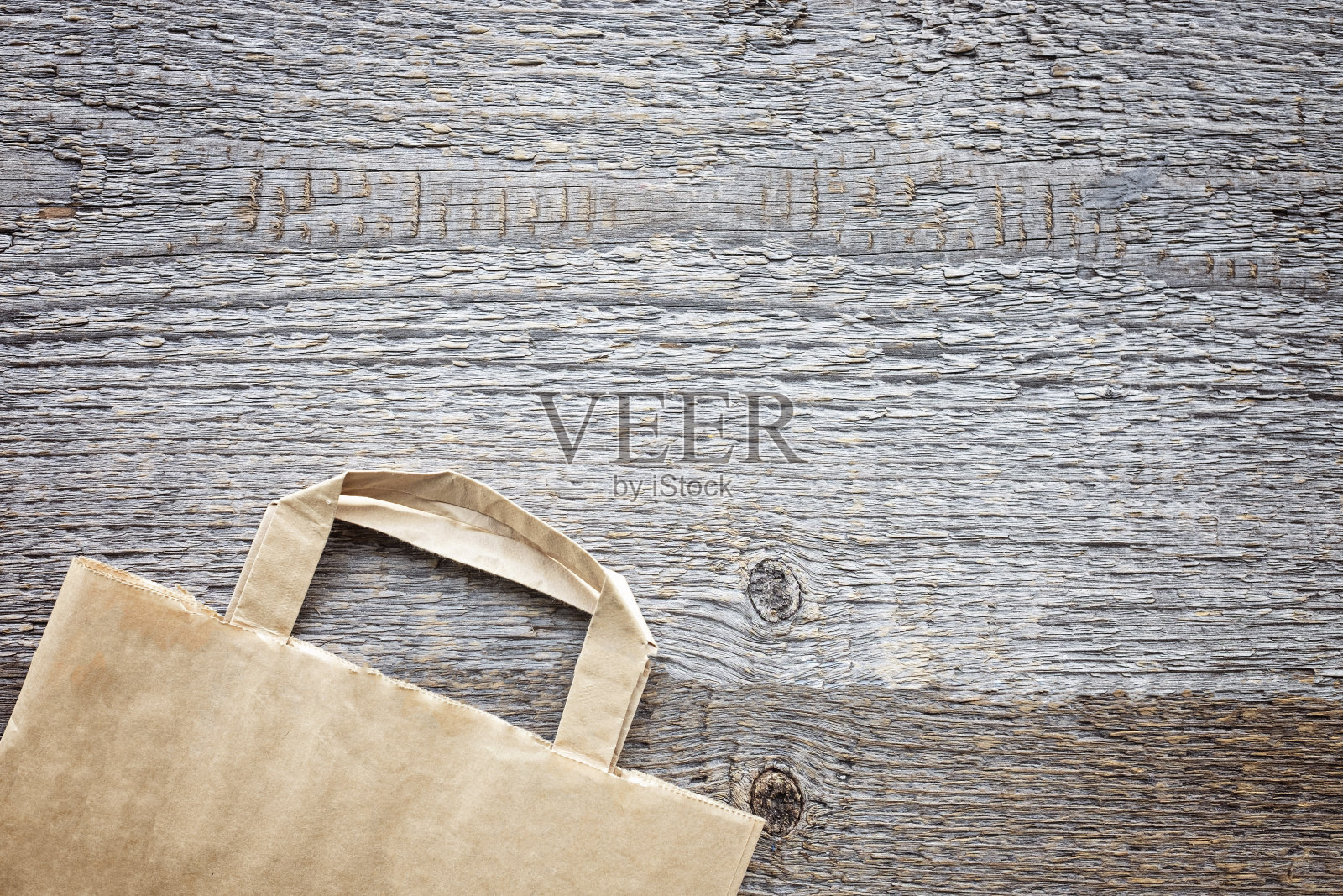 纸袋上粗糙的木板背景。现成的生态购物概念。前视图。平的。照片摄影图片