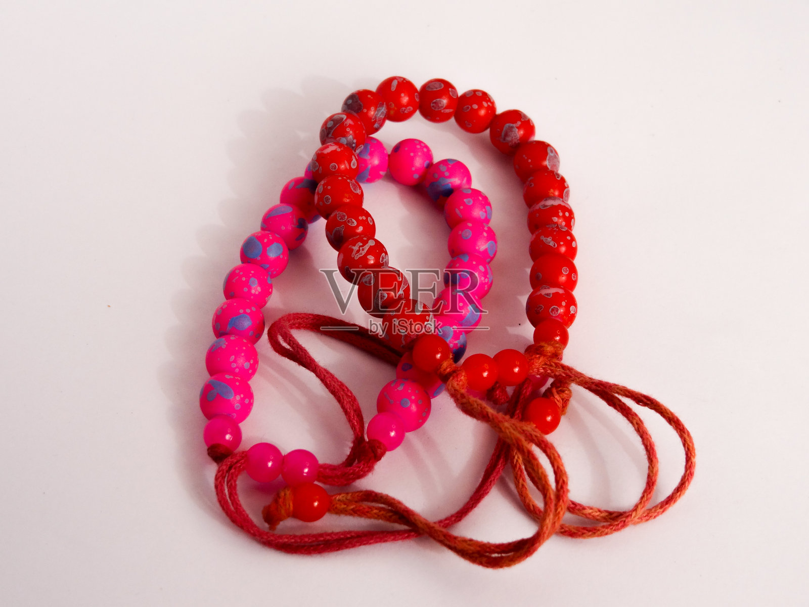 粉色和紫色手链，白色背景照片摄影图片