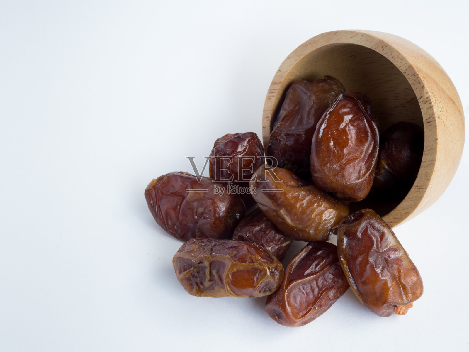 白底木碗里的枣椰树。照片摄影图片