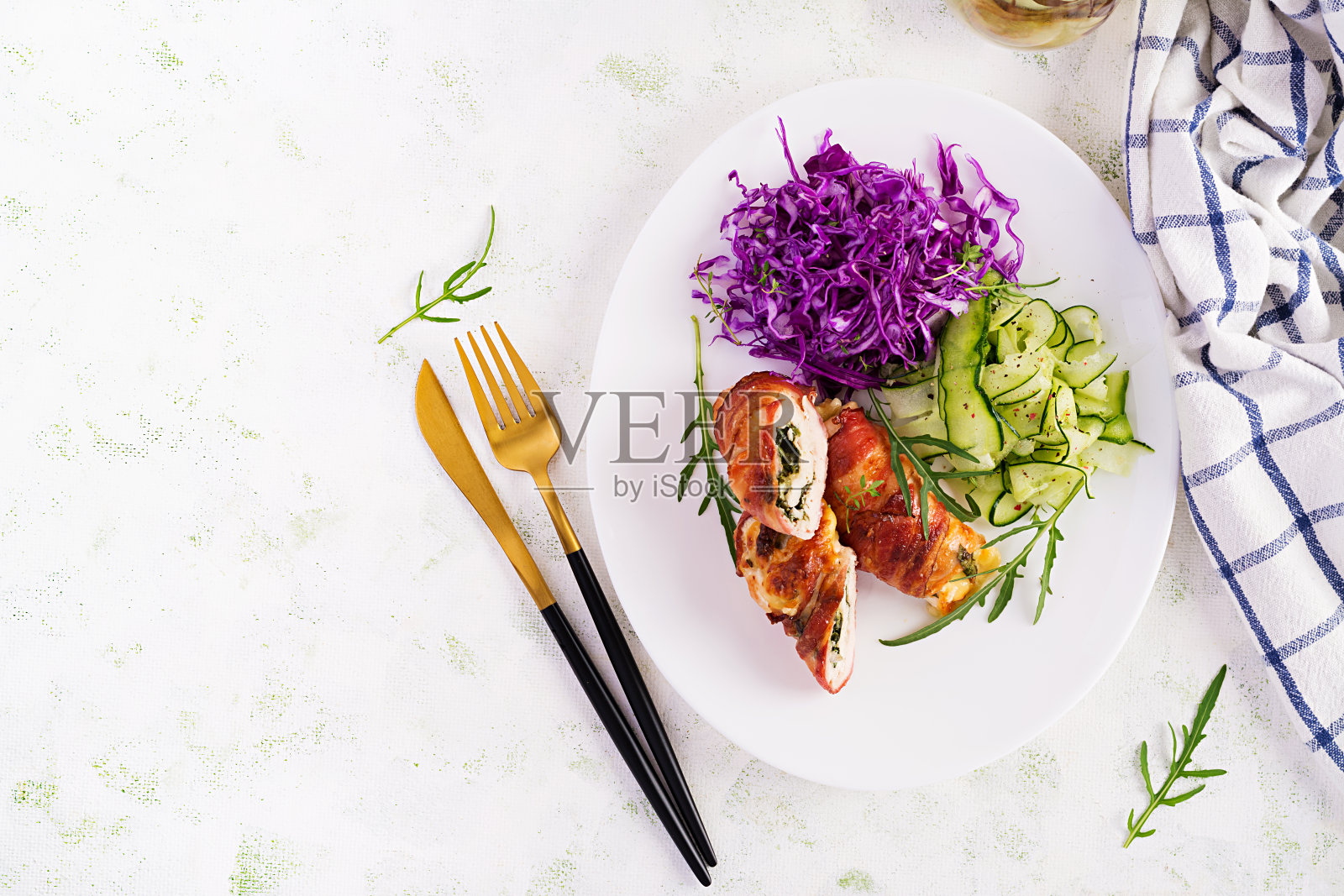 生酮饮食。晚餐配鸡肉、肉卷、培根和红卷心菜、黄瓜、芝麻菜沙拉。排毒和健康理念。酮类的食物。头顶，俯视图，平躺照片摄影图片