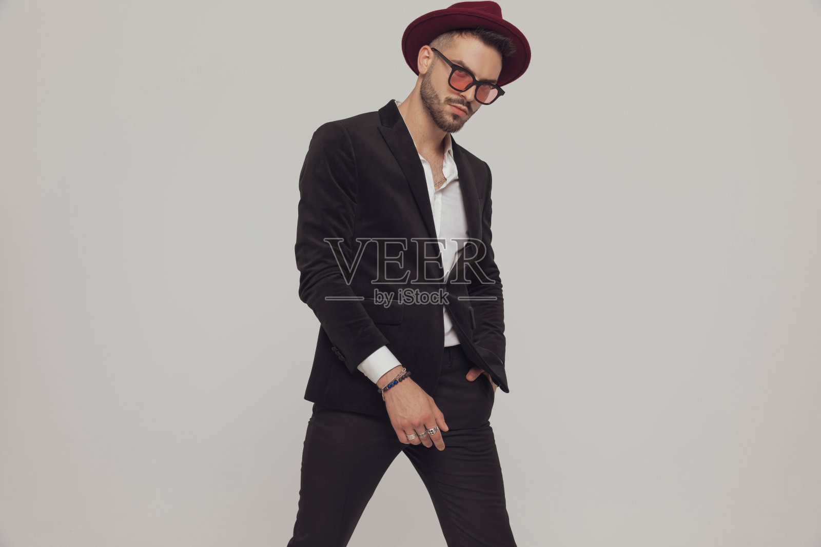 严肃的时装模特，手放在口袋里，戴着帽子照片摄影图片