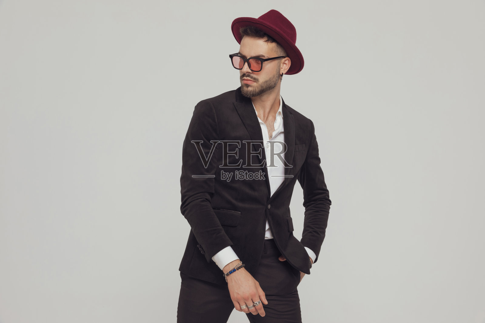 自信的时装模特好奇地看着别处，手在口袋里照片摄影图片