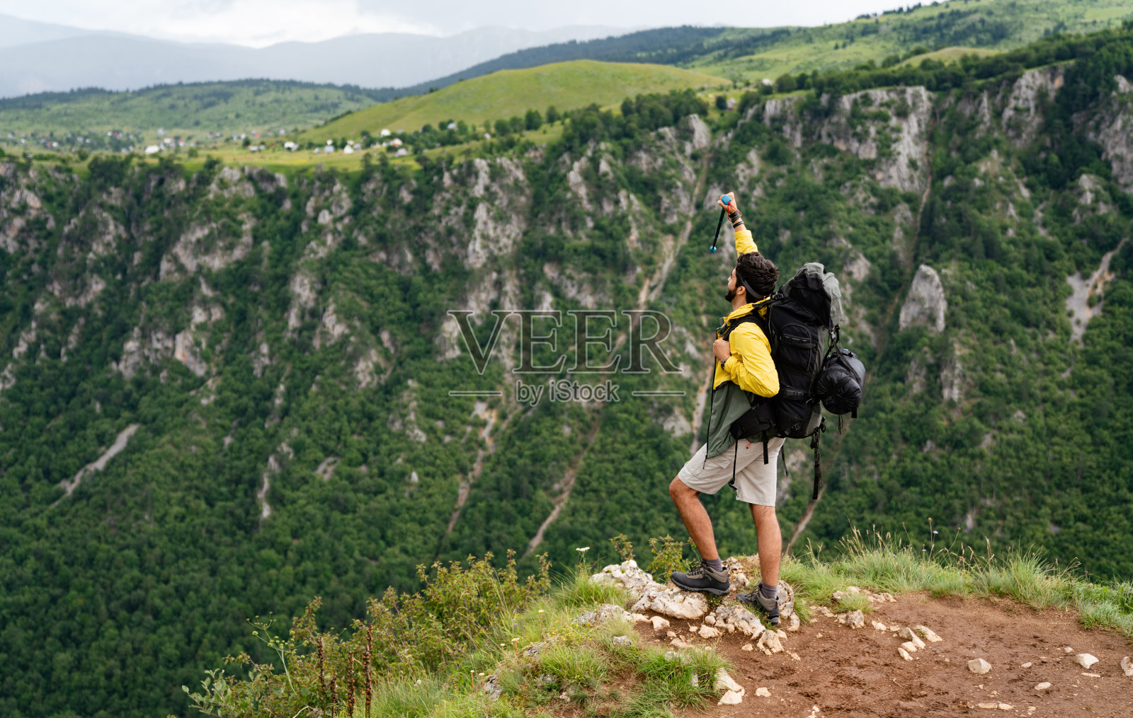 徒步者背着背包到达了山顶。成功、自由、幸福的概念照片摄影图片