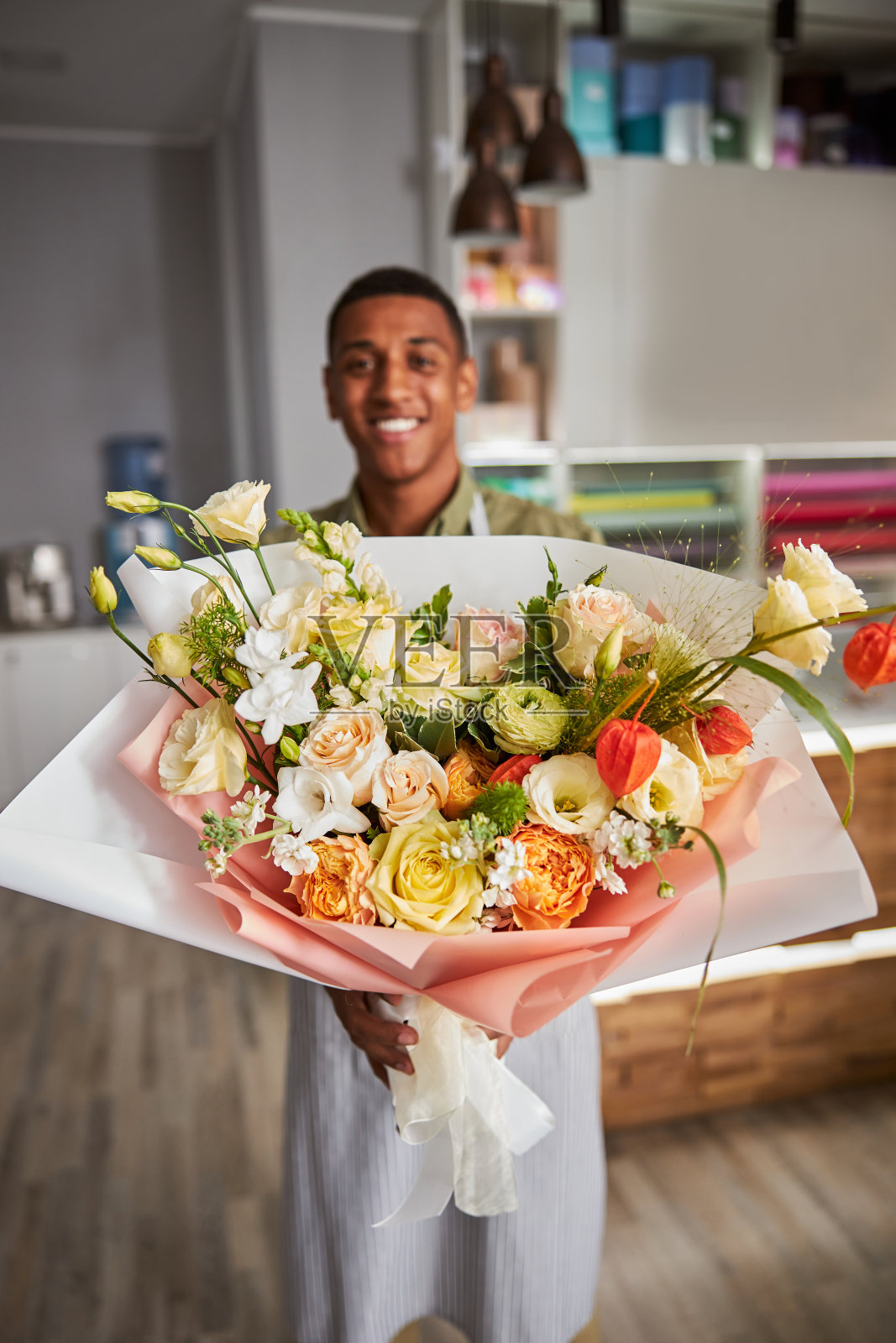 欣喜的多民族花商呈现一束花照片摄影图片