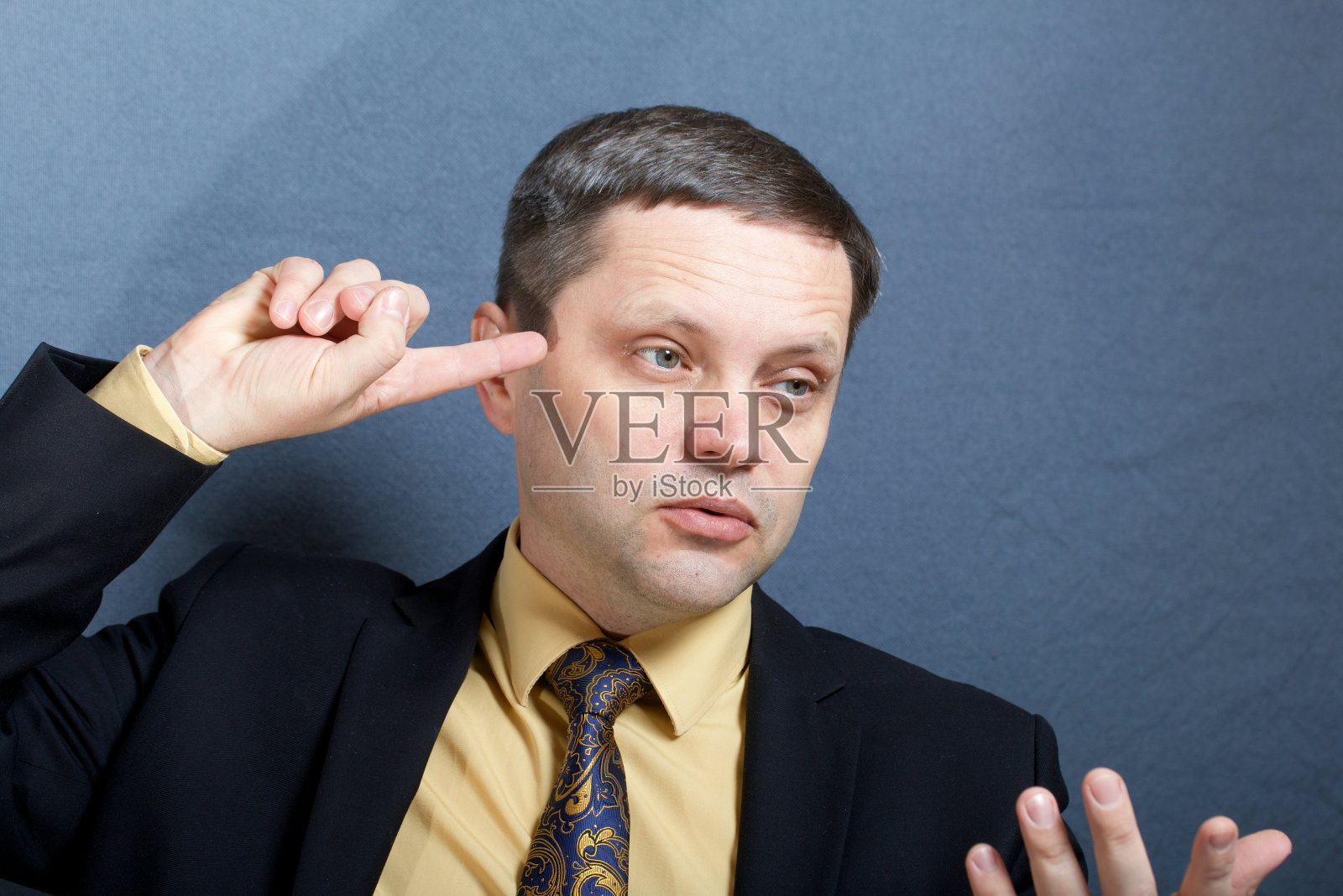 一个穿西装打领带的男人的肖像。坐在桌边，打手势。照片摄影图片