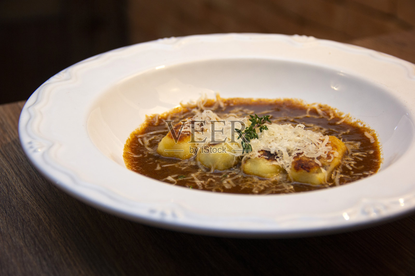 土豆团里塞满了炖牛肉，炖牛肉汤和帕达诺芝士照片摄影图片