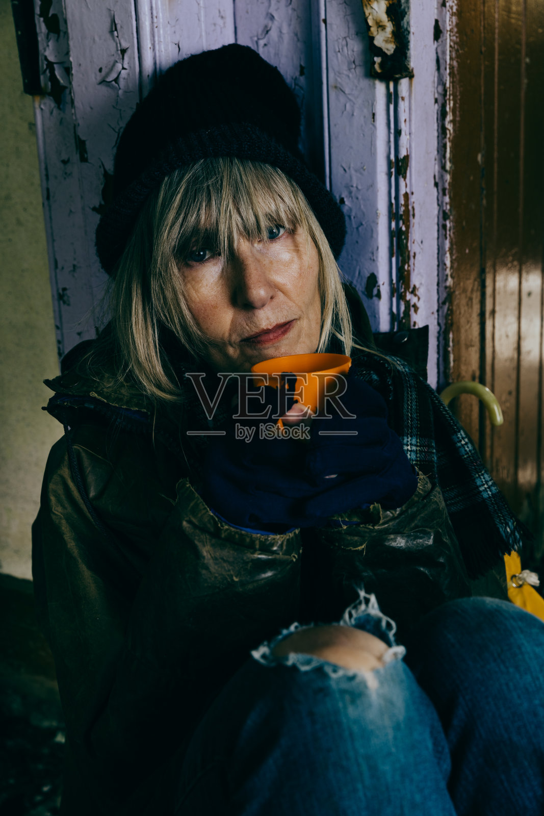 无家可归的老年妇女在一个废弃的废墟照片摄影图片