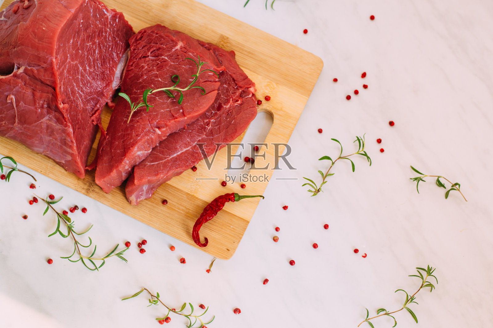 新鲜的猪肉生鱼片放在木板上。切菜板上的红牛肉。照片摄影图片