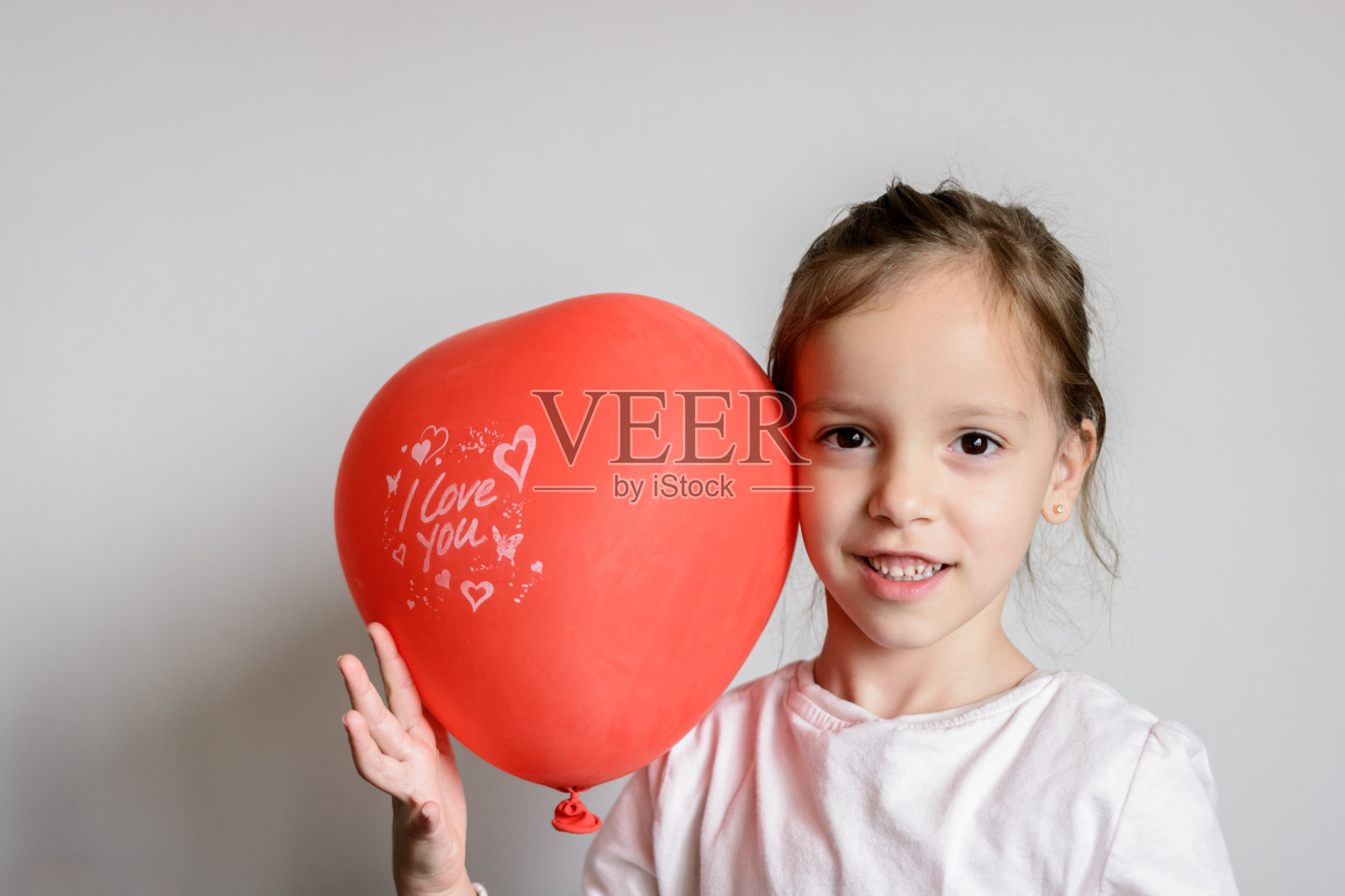 手里拿着心形气球的孩子照片摄影图片