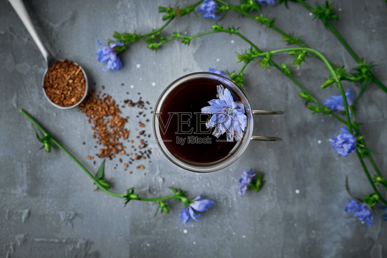 速溶菊苣根饮料在玻璃和雏鸡花在灰色混凝土背景，俯视图照片摄影图片