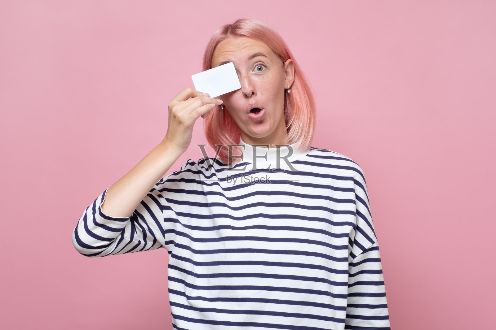 微笑的女人穿着条纹衣服拿着她的空名片照片摄影图片